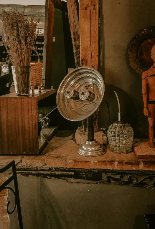 a statue sitting on top of a table next to a mirror, an art deco sculpture, pexels contest winner, rustic setting, fan favorite, gas lamps, warm interior