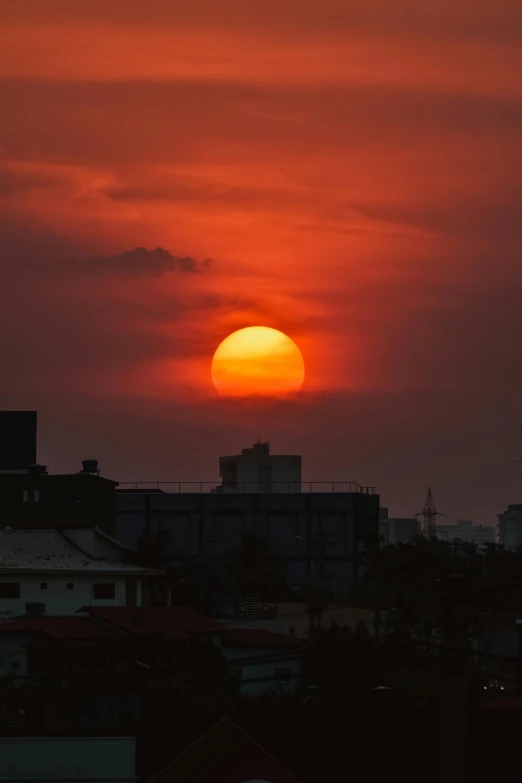 the sun is setting over the city skyline, by Sven Erixson, sri lanka, digital yellow red sun, sunset photo