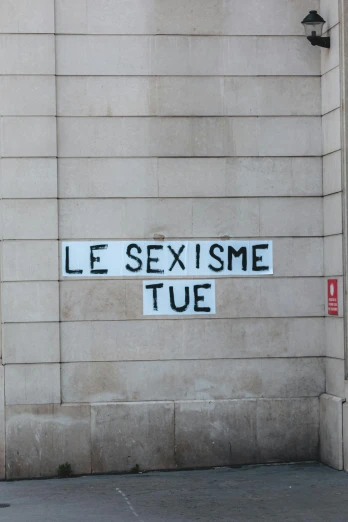 a street sign on the side of a building, a poster, by Theo Constanté, trending on pexels, feminist art, art du xixe siècle, sexually attractive, message, the best ever