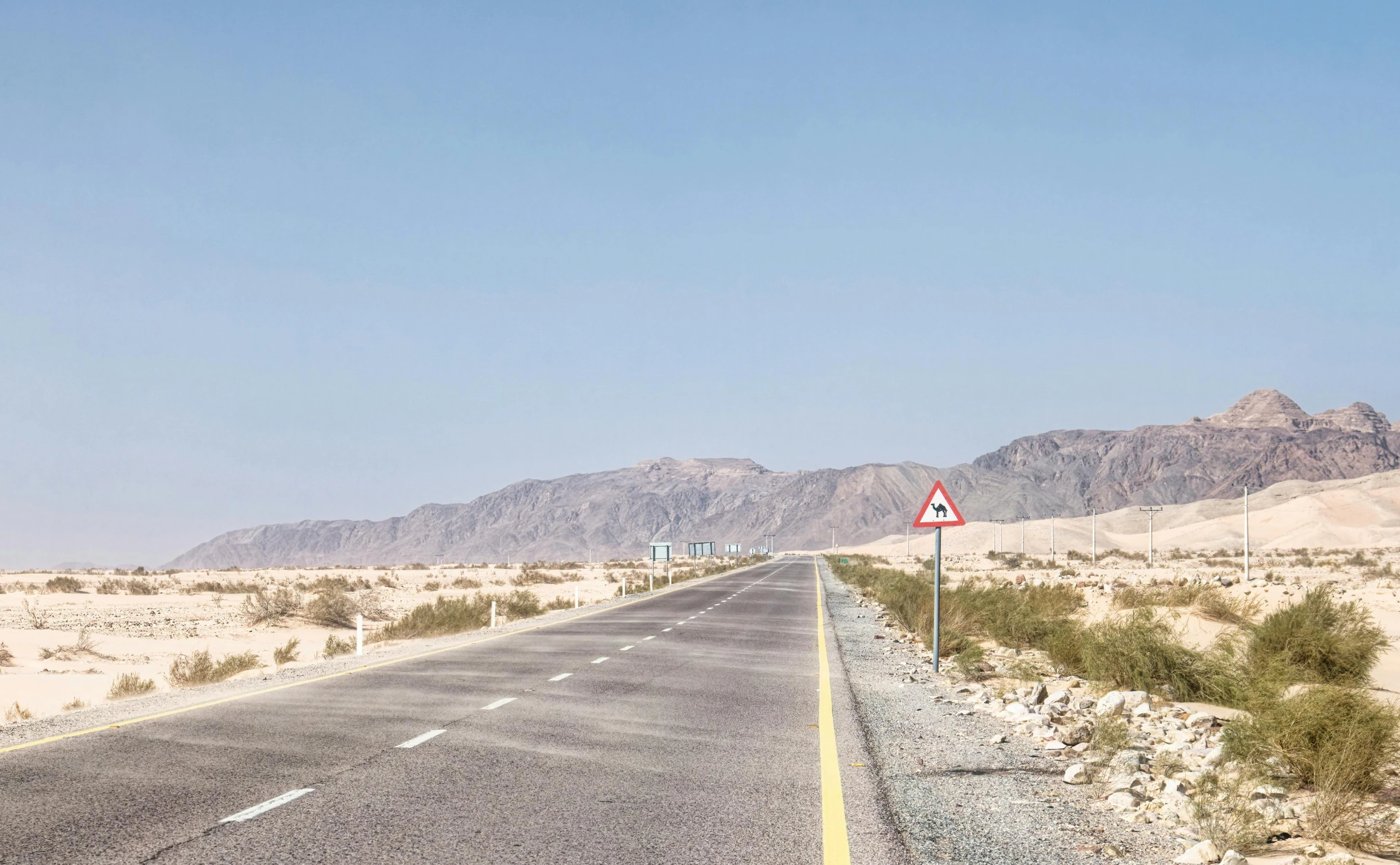 an empty road in the middle of the desert, inspired by Robert Bechtle, pexels contest winner, les nabis, traffic signs, red sea, joel sternfeld, slight haze