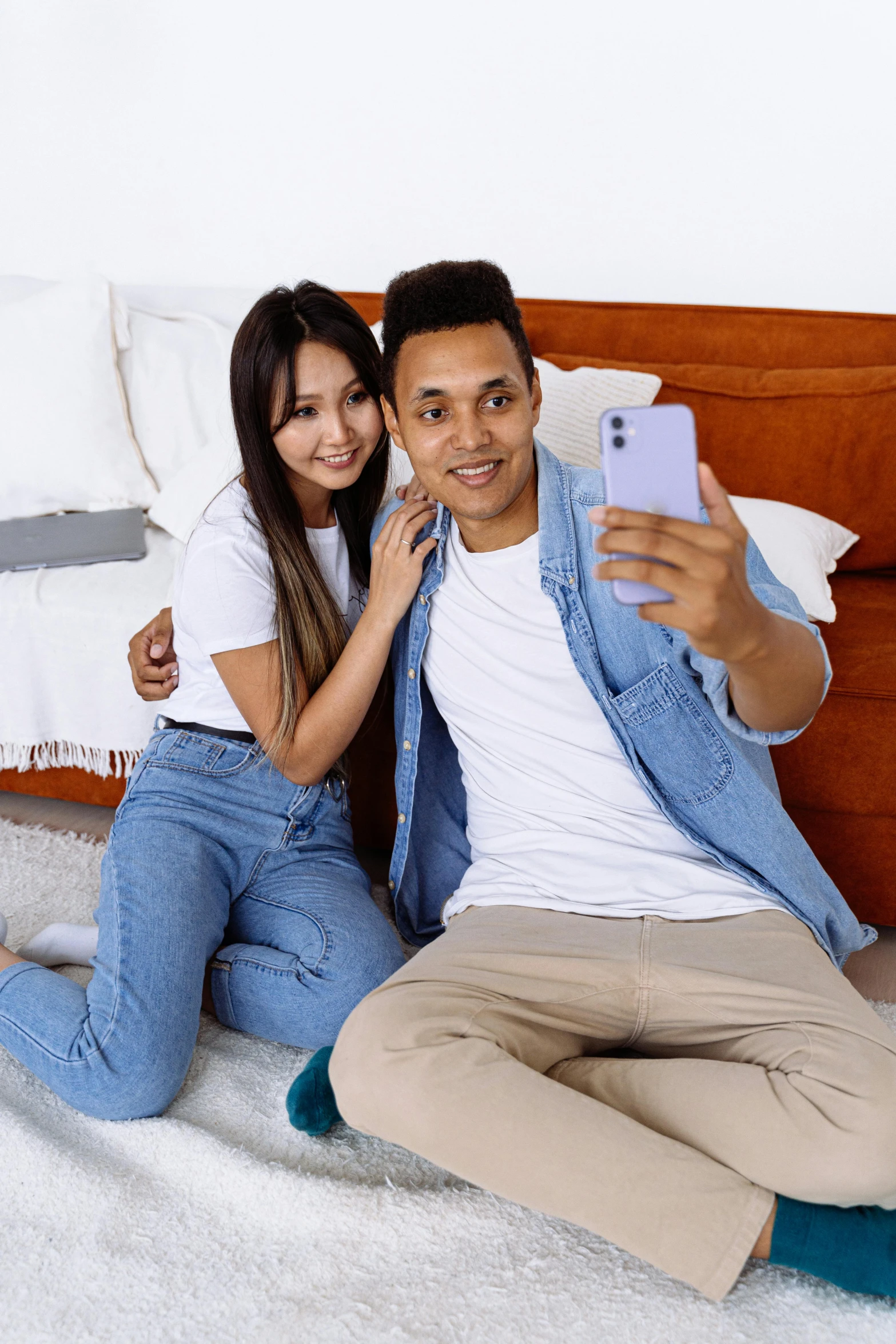 a man and woman sitting on a bed taking a selfie, wearing jeans, jakarta, profile image, promotional image