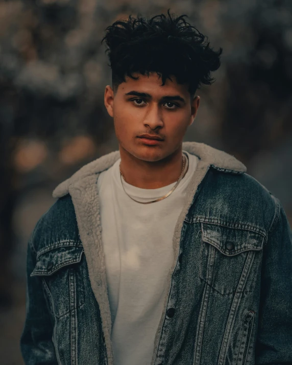 a young man wearing a denim jacket and a white t - shirt, by Cosmo Alexander, trending on pexels, lgbtq, color corrected, ayan nag, dressed in a gray