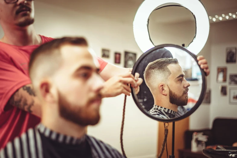 a man getting his hair cut at a barber shop, a photo, by Niko Henrichon, trending on pexels, square masculine facial features, looking into a mirror, 2717433015, full colour