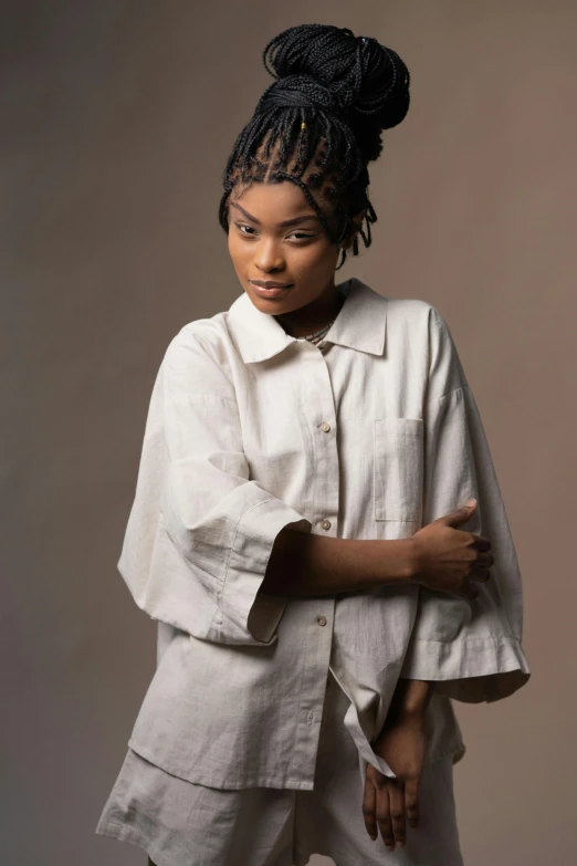 a woman wearing a white shirt and white pants, an album cover, by Chinwe Chukwuogo-Roy, trending on pexels, renaissance, portrait of zendaya, twisted braids, woman is in a trenchcoat, neutral pose