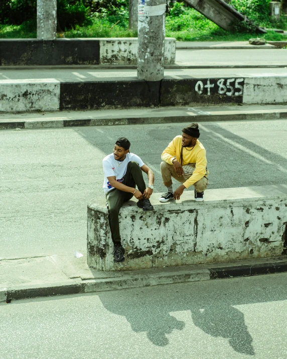 a couple of men sitting on top of a cement bench, an album cover, pexels contest winner, riyahd cassiem, on a road, ( ( theatrical ) ), low quality footage