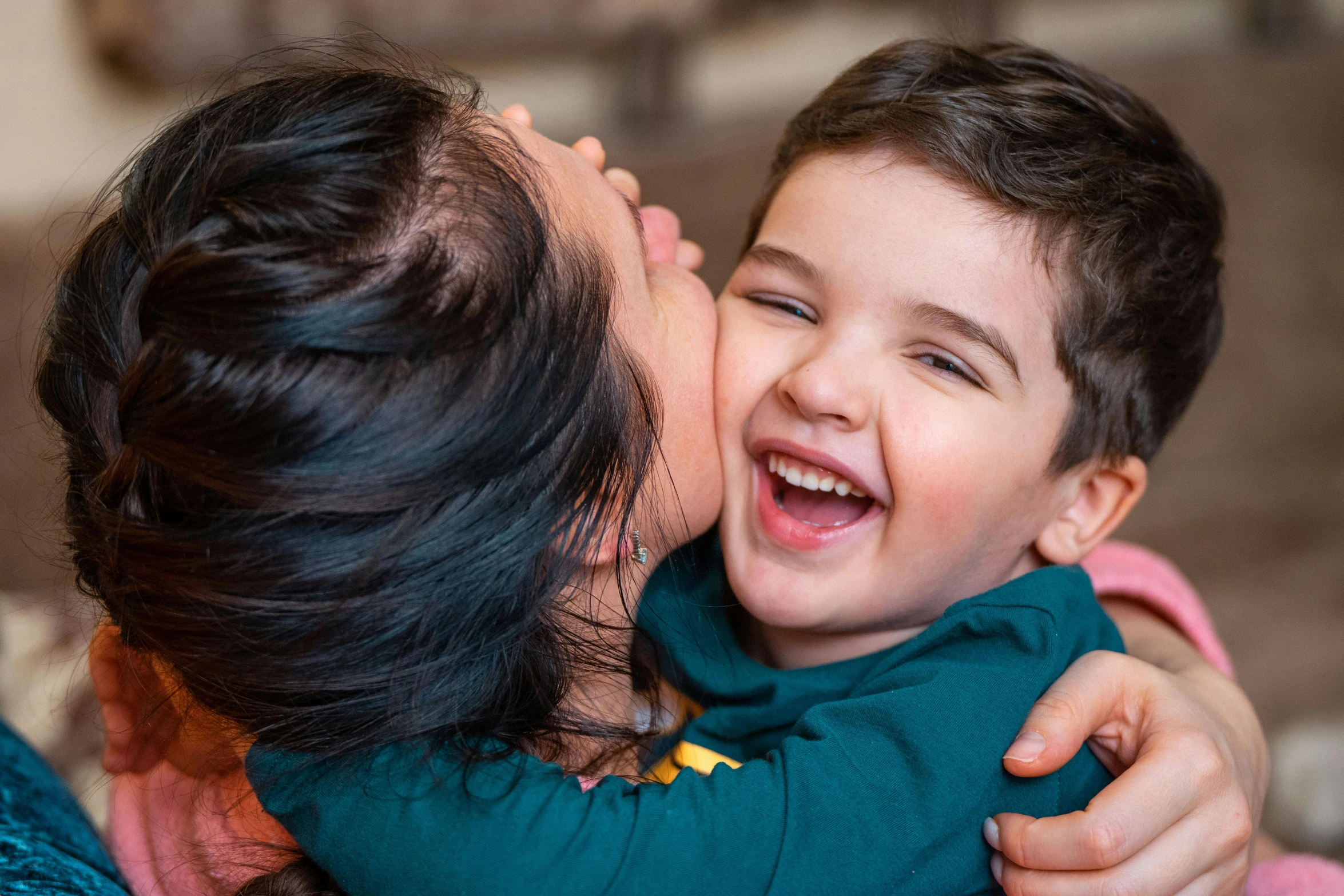 a woman giving a child a kiss on the cheek, pexels contest winner, mutahar laughing, ethan klein, profile image, closeup - view