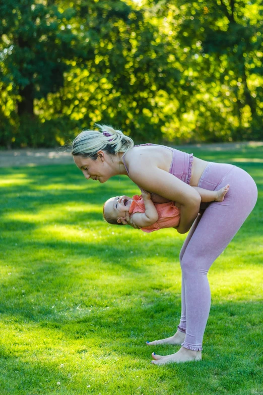 a woman doing a yoga pose with a baby, an album cover, by Nina Hamnett, pexels contest winner, blond, square, high quality photo, al fresco