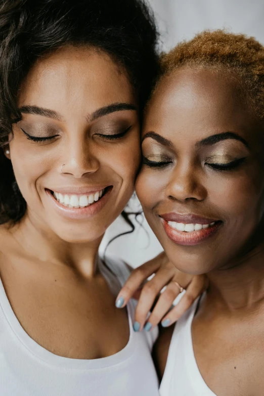 a couple of women standing next to each other, natural skin tones, smiling softly, iridescent skin, supportive