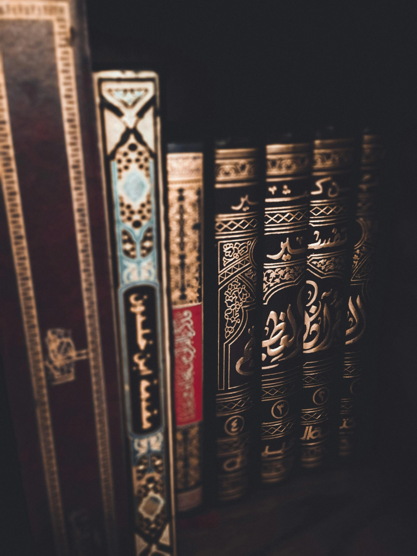 a row of books sitting on top of a wooden shelf, arabic calligraphy, dimly lit, ((intricate)), book cover art