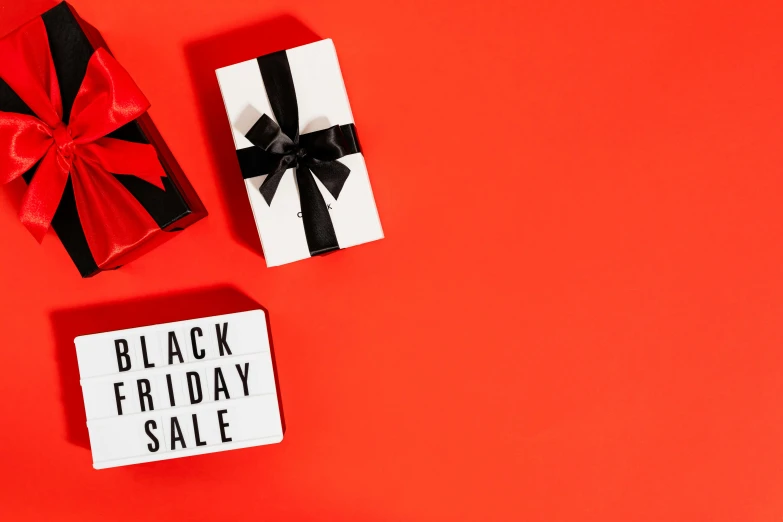 a black friday sale sign next to a gift box, by Julia Pishtar, hurufiyya, black and red only, product advertising, thumbnail, opening shot