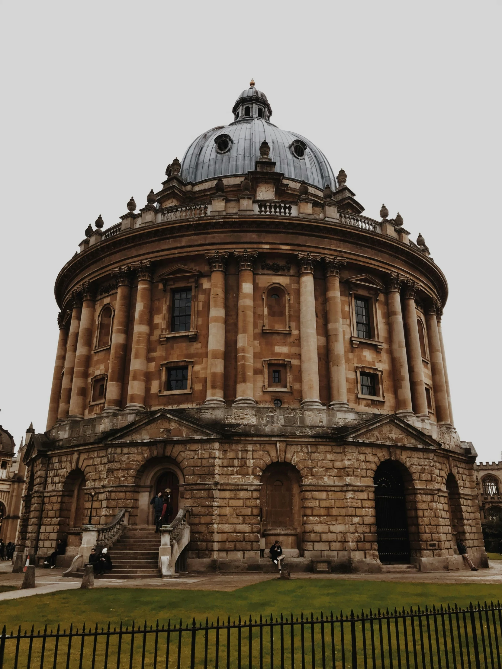 a large building sitting on top of a lush green field, by Adam Rex, pexels contest winner, renaissance, daniel oxford, dome, grey skies, 🎀 🍓 🧚