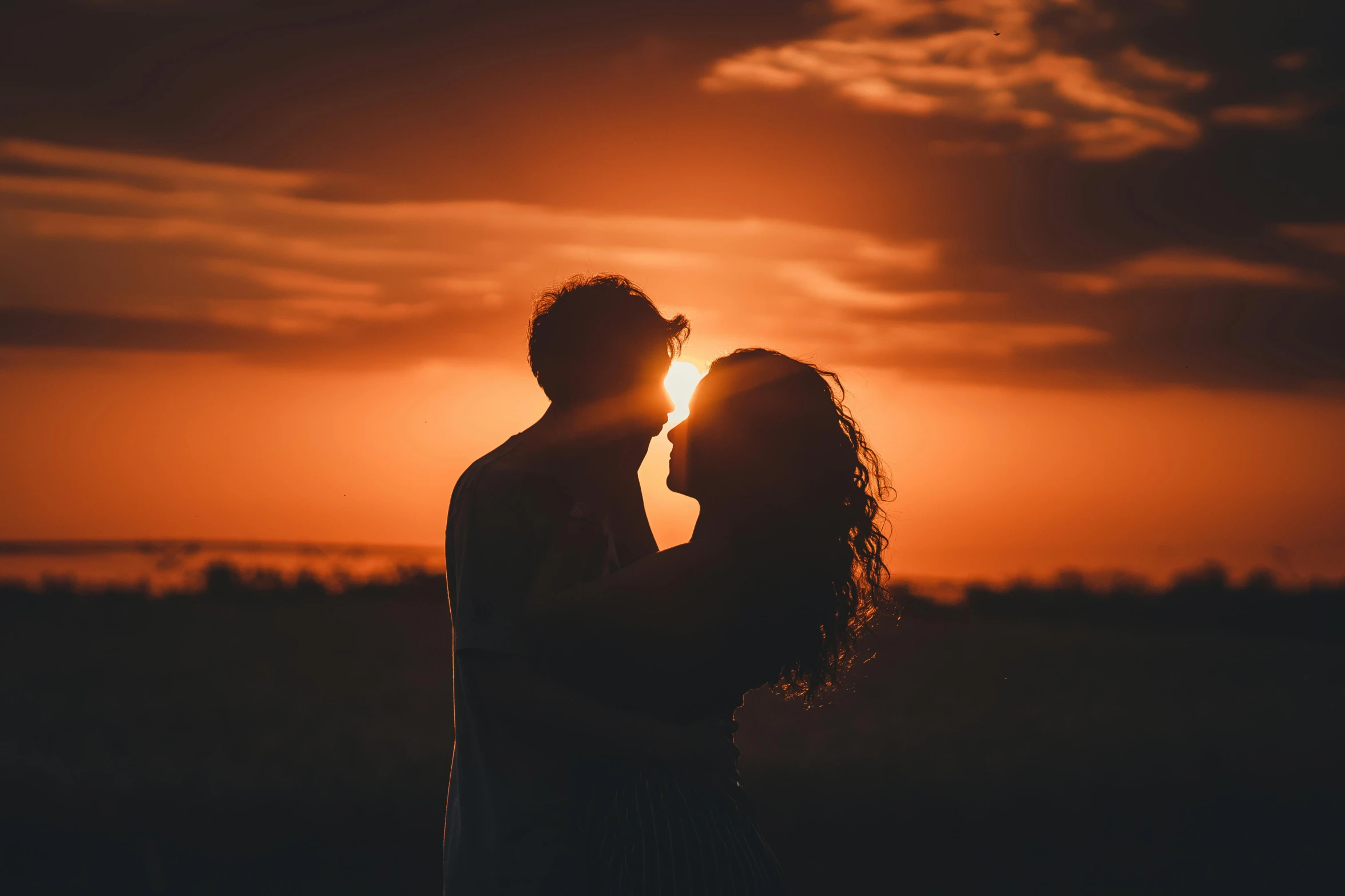 a man and woman kissing in front of a sunset, pexels contest winner, back lit, ad image, orange lit sky, high quality image