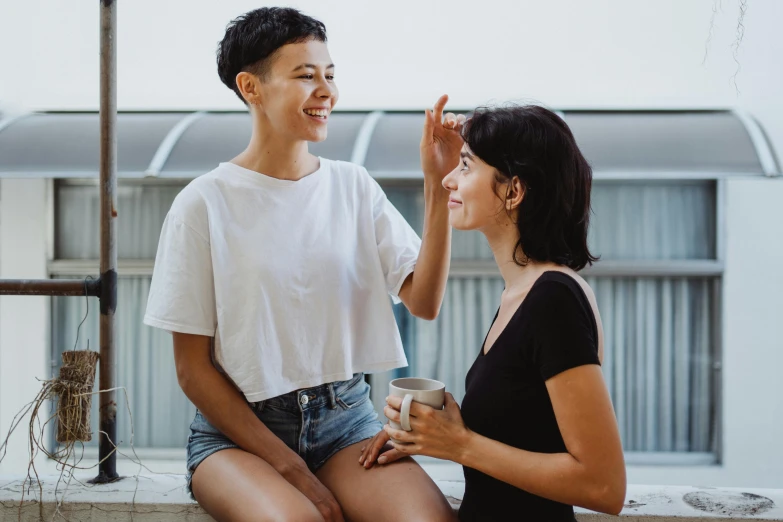 a couple of women sitting next to each other, pexels contest winner, happening, wearing a cute top, with short hair, ad image, friendly