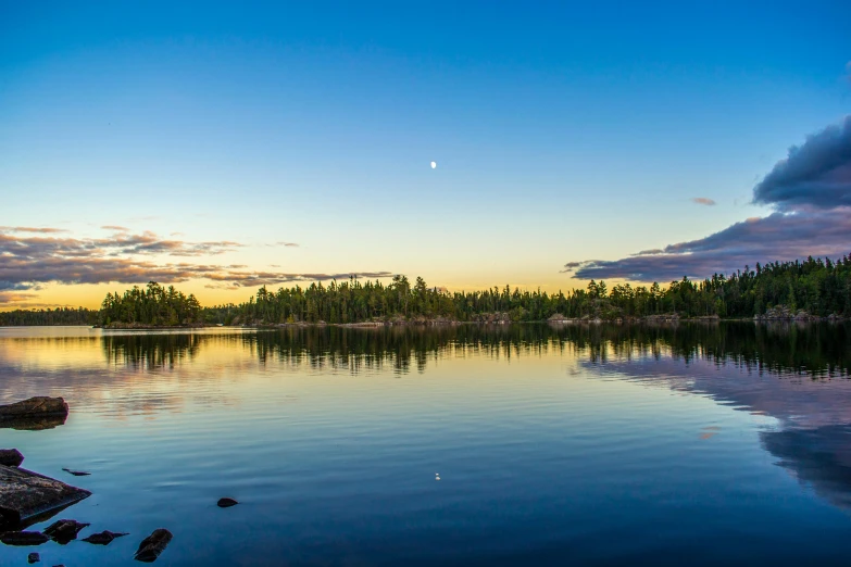 a large body of water surrounded by trees, by Jesper Knudsen, unsplash, crescent moon in background, archipelago, minn, inlets