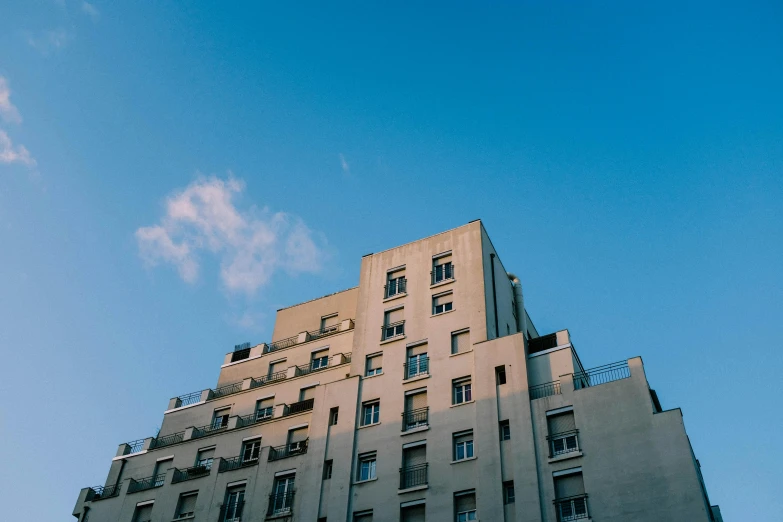 a tall building with a clock on top of it, inspired by Elsa Bleda, unsplash, neoclassicism, plain uniform sky, soviet apartment buildings, cinematic paris, 2 0 0 0's photo