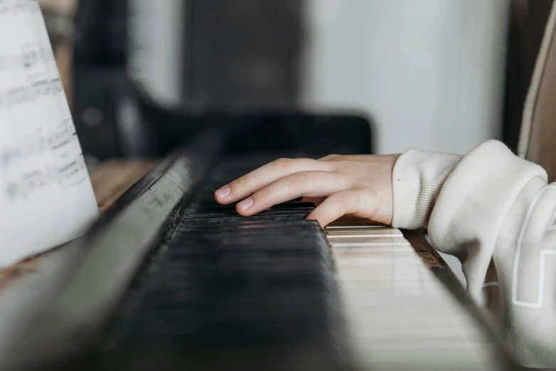 a close up of a person playing a piano, profile image, children, looking towards the camera, background image