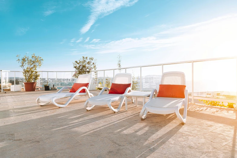 a couple of lawn chairs sitting on top of a roof, pexels contest winner, orange and white color scheme, mediterranean vista, 3 - piece, at future neon light rooftop