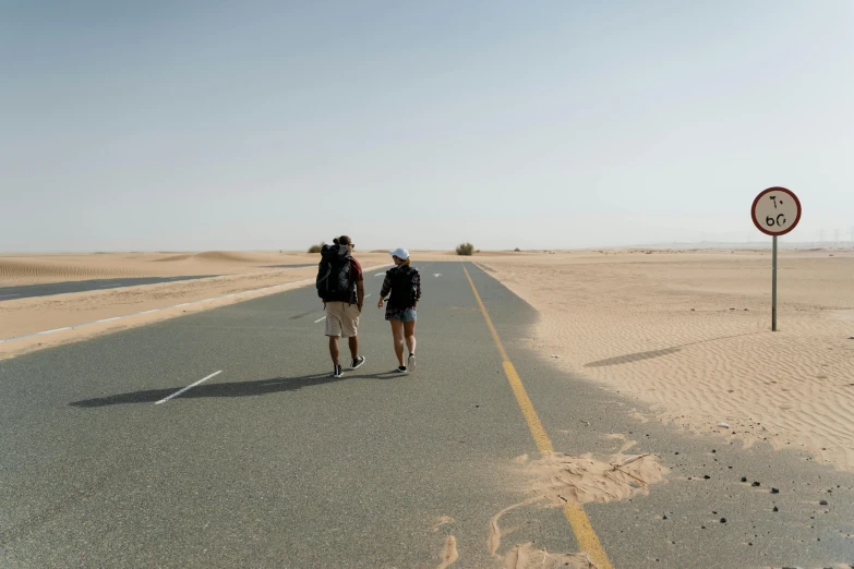 a couple of people that are walking down a road, les nabis, sand sea, profile image, flat roads, facing away from the camera