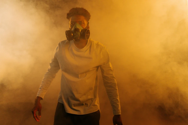 a man wearing a gas mask standing in smoke, afrofuturism, 2 1 savage, jayson tatum as guerilla heroica, 2019 trending photo, yellow mist