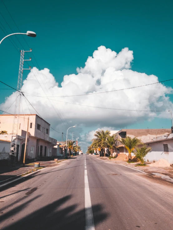 a street lined with houses and palm trees, an album cover, pexels contest winner, prismatic cumulus clouds, wide roads, profile image, cuban setting