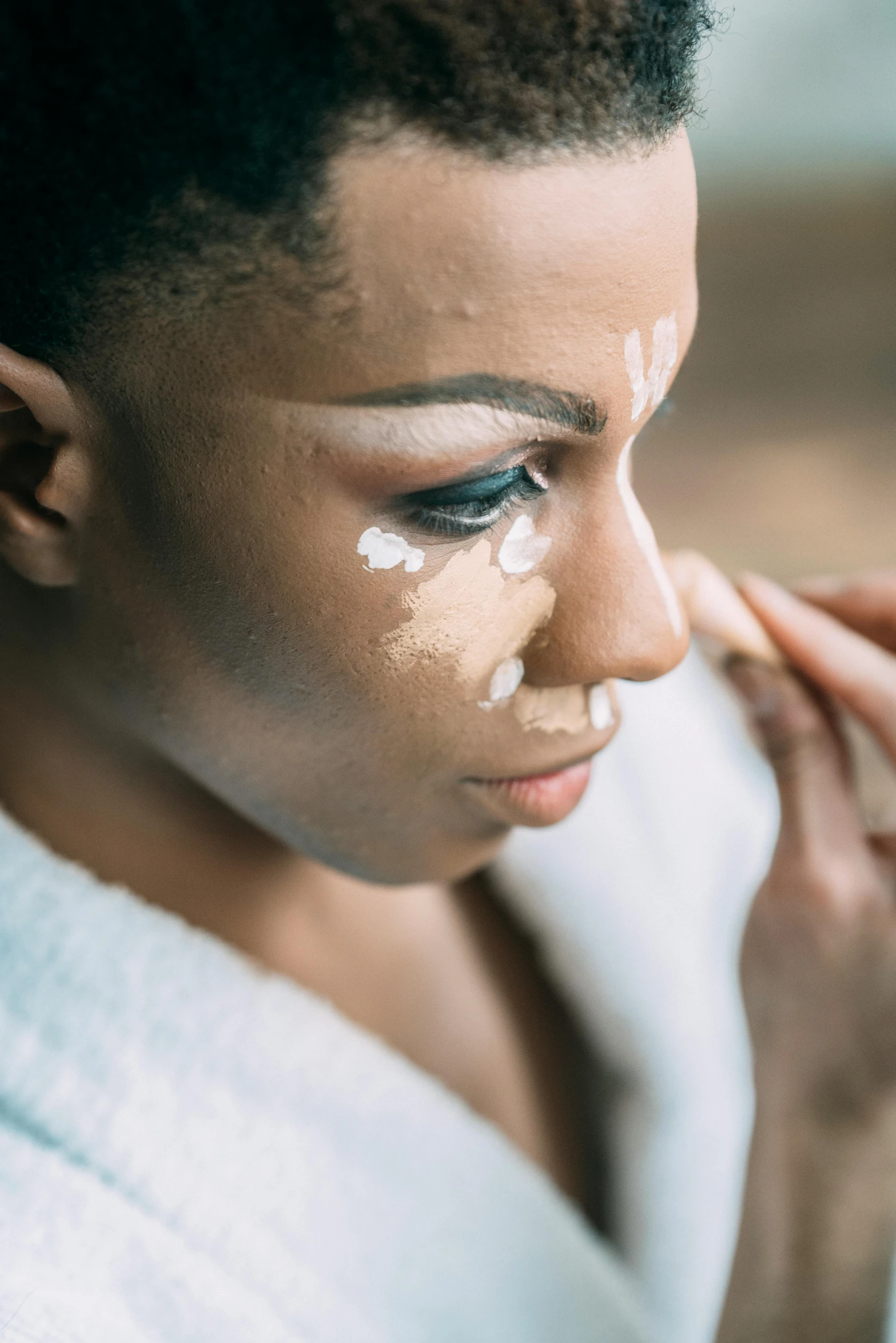 a woman is putting cream on her face, trending on pexels, afrofuturism, markings on his face, left eye stripe, tan complexion, “ painting