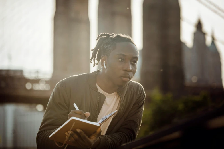 a man with dreadlocks writing on a book, pexels contest winner, happening, black teenage boy, portrait of tall, afternoon, pondering