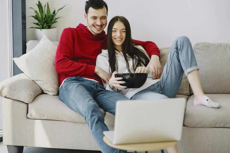 a man and a woman sitting on a couch with a laptop, pexels, movie promotional image, lachlan bailey, maintenance, playing games