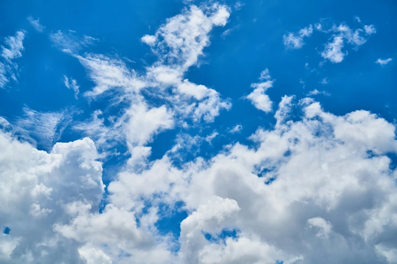 a plane flying through a cloudy blue sky, by Jan Rustem, unsplash, prismatic cumulus clouds, high resolution photo, looking up, slide show