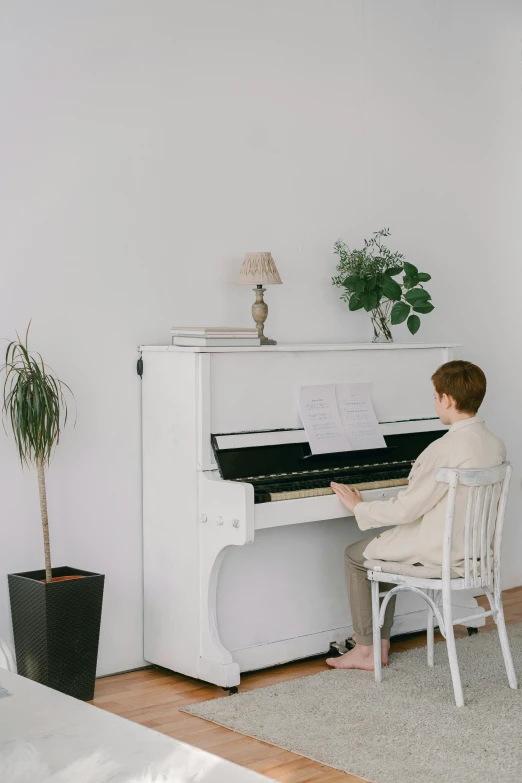 a person sitting at a piano in a room, on a white table