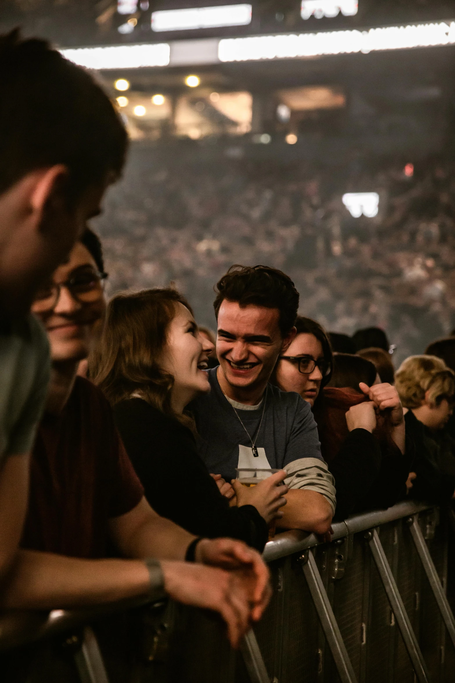 a group of people standing next to each other at a concert, a picture, pexels contest winner, happening, smiling at each other, in an arena pit, looking around a corner, smiling maniacally