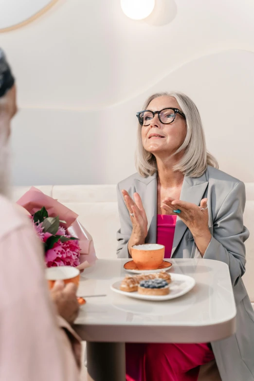 two women sitting at a table talking to each other, pexels contest winner, older woman, sitting on a mocha-colored table, woman with rose tinted glasses, eating cakes