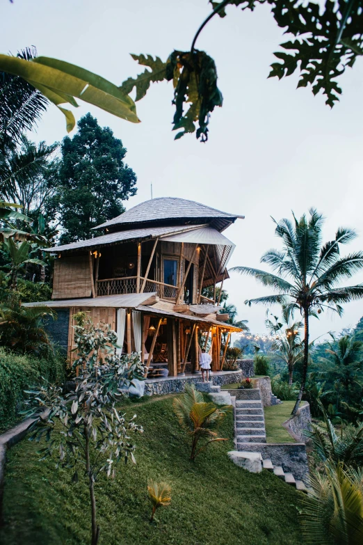 a house sitting on top of a lush green hillside, sumatraism, luxurious wooden cottage, wedding, lit up, boho