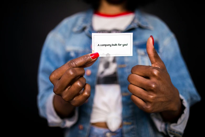 a close up of a person holding a business card, by Julia Pishtar, pexels contest winner, black arts movement, thumb up, black young woman, an elf, 15081959 21121991 01012000 4k