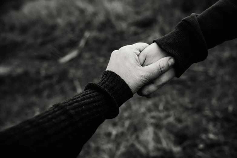 a black and white photo of two people holding hands, a black and white photo, unsplash, romanticism, ignant, let's be friends, holding a 🛡 and an 🪓, struggling