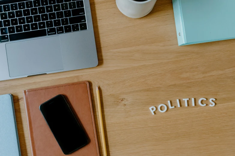 a laptop computer sitting on top of a wooden desk, a cartoon, by Julia Pishtar, trending on pexels, purism, politics, words, phone photo, politicians