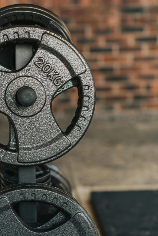 a pair of weights sitting on top of a bench, rugged details, zoomed in, cast iron material, 2 0 0 mm focus