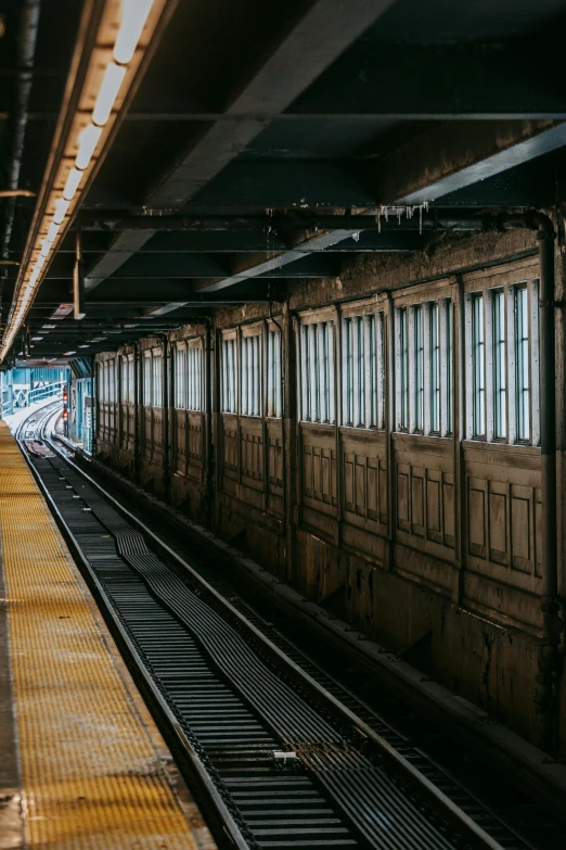 a train pulling into a train station next to a platform, by Carey Morris, unsplash contest winner, new york alleyway, rows of doors, panoramic shot, brown