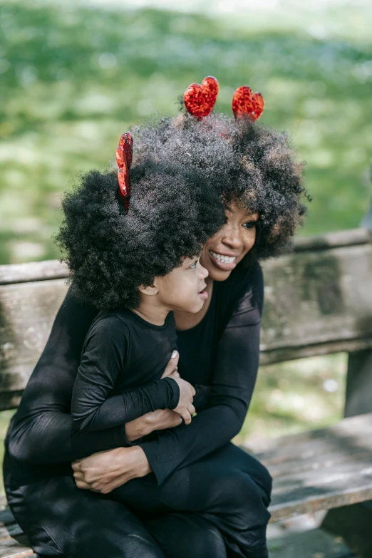 a woman and a child sitting on a bench, natural hair, devil horns, portrait featured on unsplash, wig