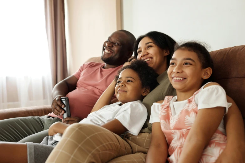 a group of people sitting on top of a couch, family friendly, profile image, black people, cinema still