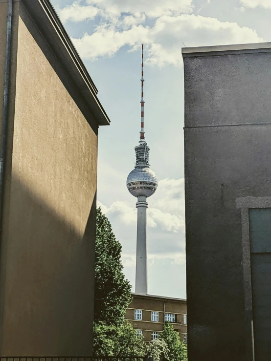 a tall building with a television tower in the background, a photo, unsplash contest winner, berlin secession, promo image, 2000s photo, photo on iphone, hyper - detailed color photo