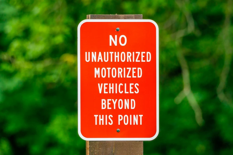 a red sign that says no unauthorizedized motorized vehicles beyond this point, by Tony Szczudlo, unsplash, off-roading, vandalism, istockphoto, y 2 k
