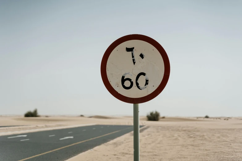 a red and white sign sitting on the side of a road, unsplash, in the desert beside the gulf, 7 0 years old, speed, no numbers