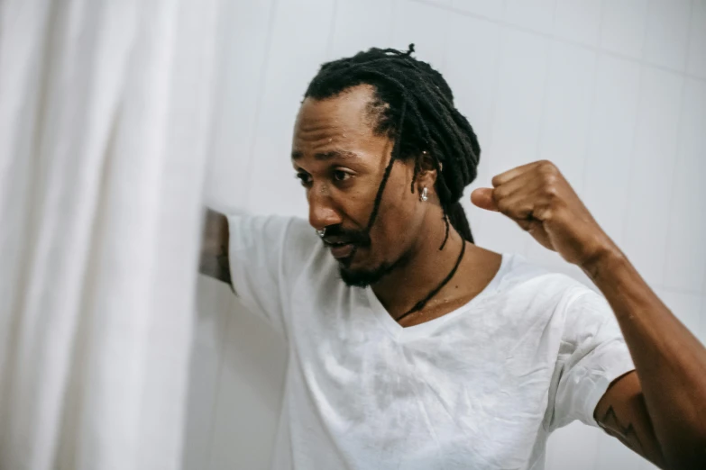 a man with dreadlocks standing in front of a shower, pexels contest winner, happening, dressed in a white t shirt, angry and pointing, kara walker james jean, profile image