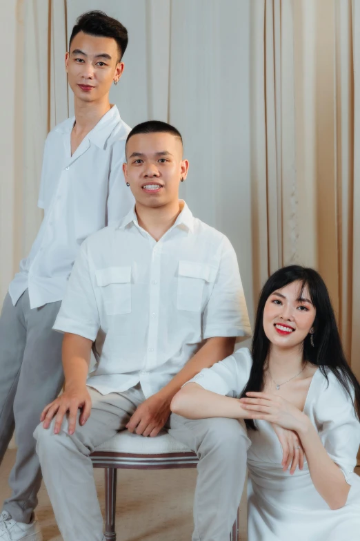 a group of people sitting next to each other, an album cover, inspired by Ruth Jên, wearing a linen shirt, portrait of family of three, wearing white clothes, background image