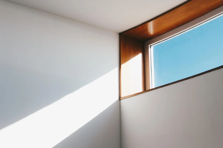 a bath room with a toilet and a window, inspired by Tadao Ando, unsplash, light and space, shaft of sun through window, angular minimalism, window, backlite