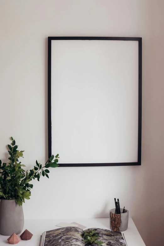 a picture frame hanging on a wall above a desk, unsplash, postminimalism, white backdrop, 144x144 canvas, iron frame, large tall