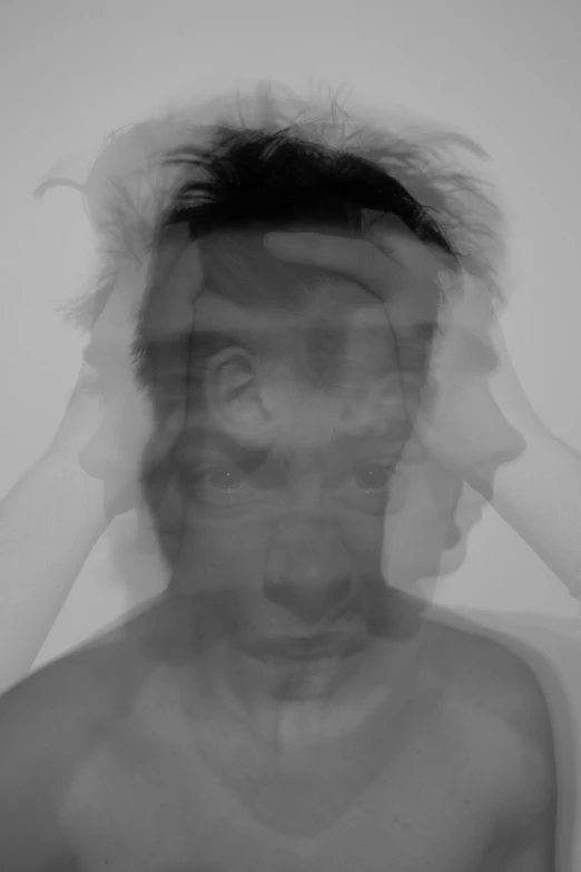 a black and white photo of a man covering his face, inspired by Anna Füssli, conceptual art, 3 heads, ((mist)), distorted photo, album cover