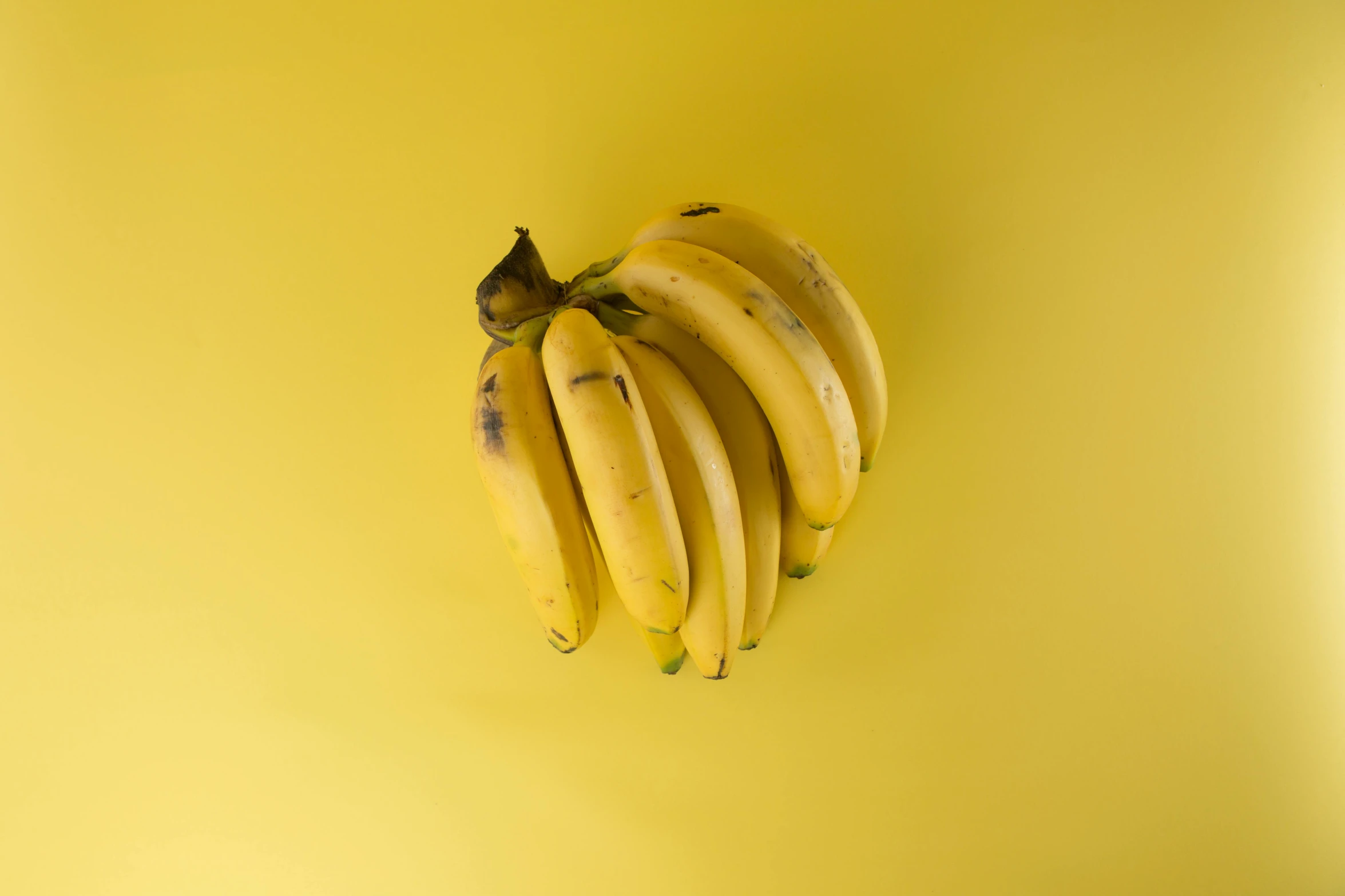 a bunch of bananas on a yellow surface, trending on pexels, grey, taken with sony alpha 9, coloured, embracing