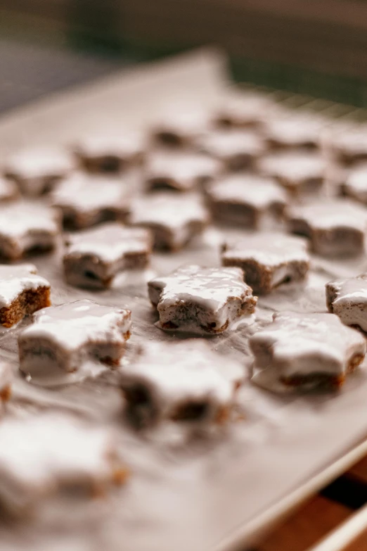 a close up of a tray of food on a table, a tilt shift photo, by Julia Pishtar, snowflakes, white with chocolate brown spots, star roof, thumbnail