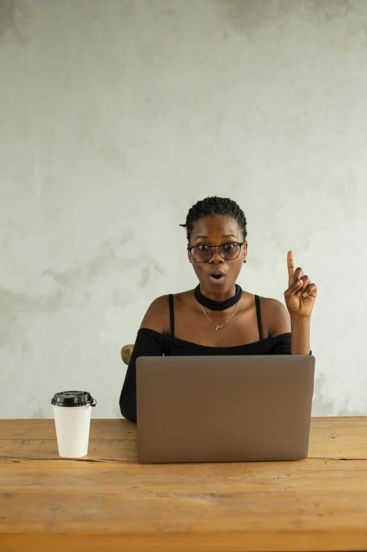 a woman sitting at a table with a laptop, trending on pexels, afrofuturism, shrugging, giving a speech, college students, an ancient